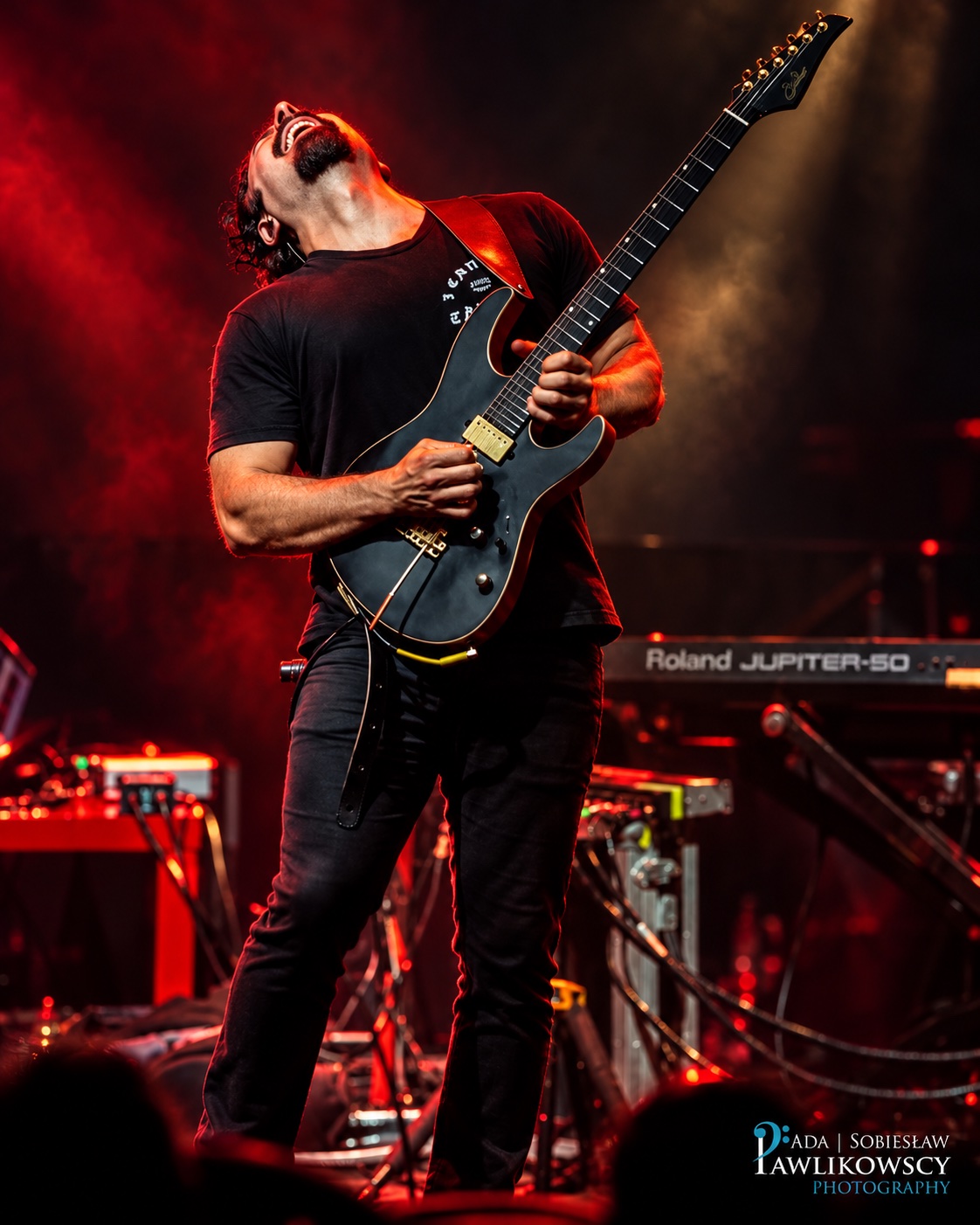 André Nieri tocando guitarra sob iluminação cinematográfica vermelha